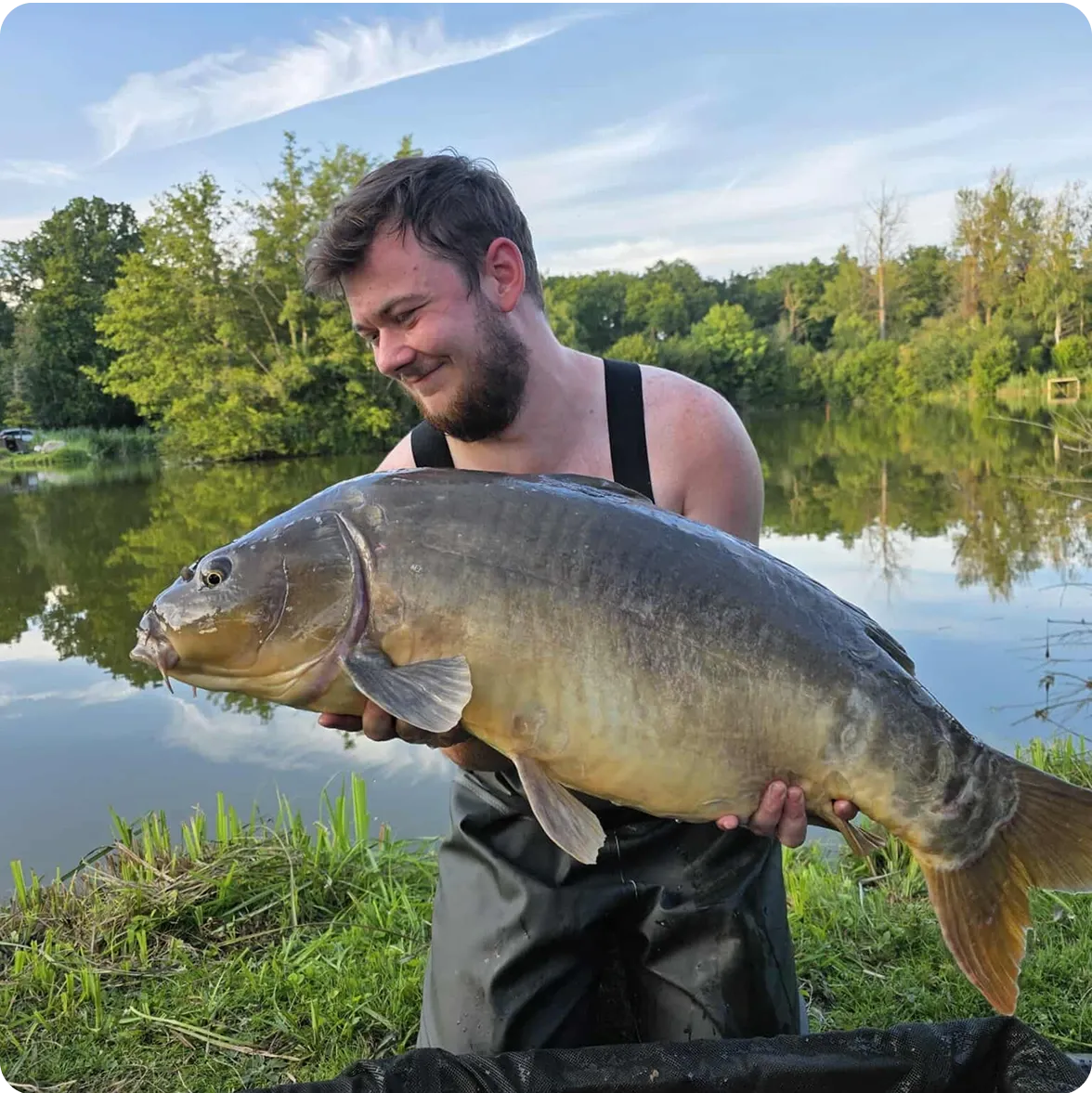 Homme barbu tenant un gros poisson dans ses mains