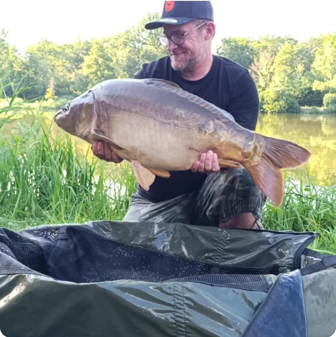 Homme tenant un gros poisson dans ses mains